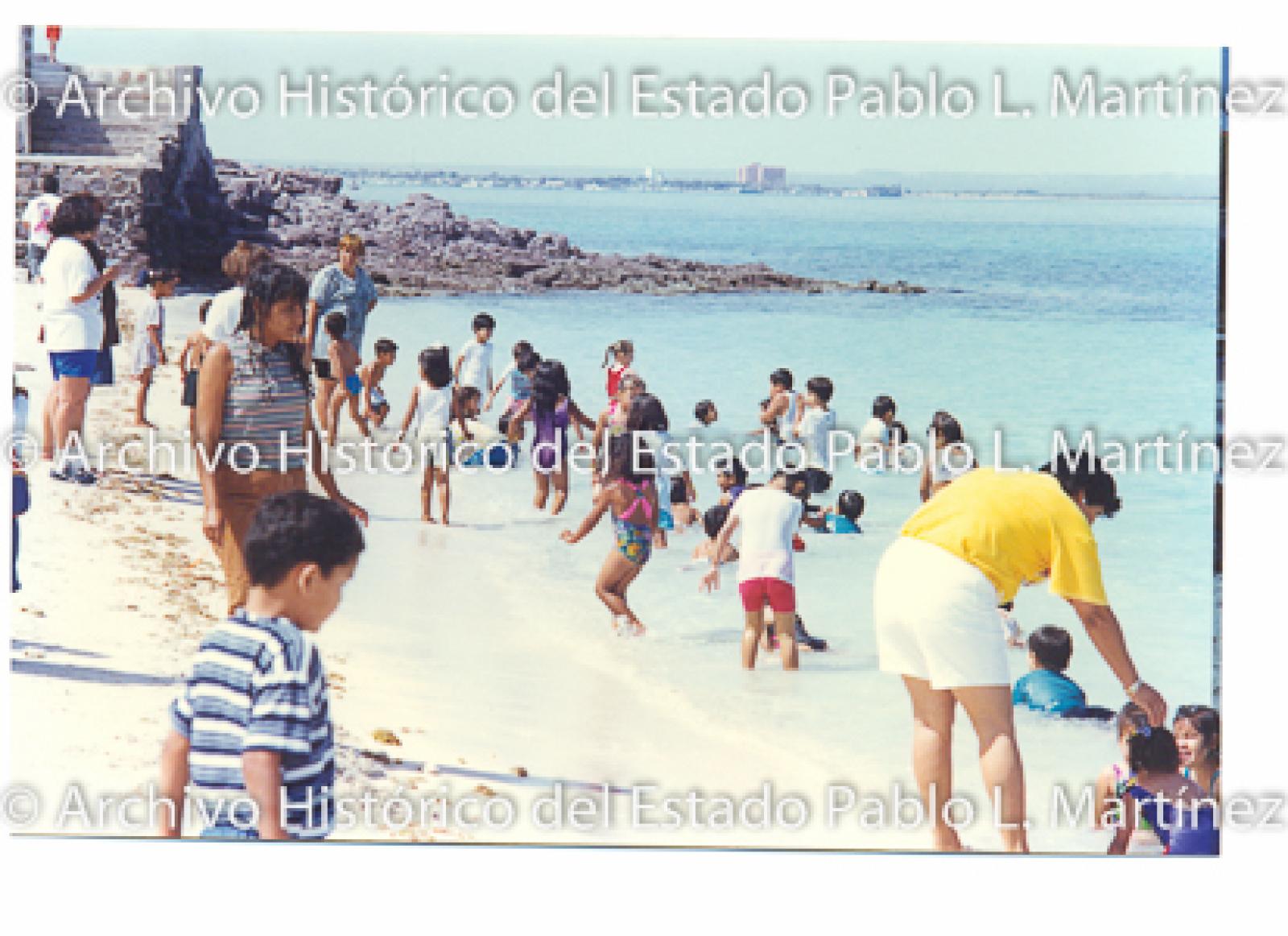 Mujeres y niños en orilla de la playa.