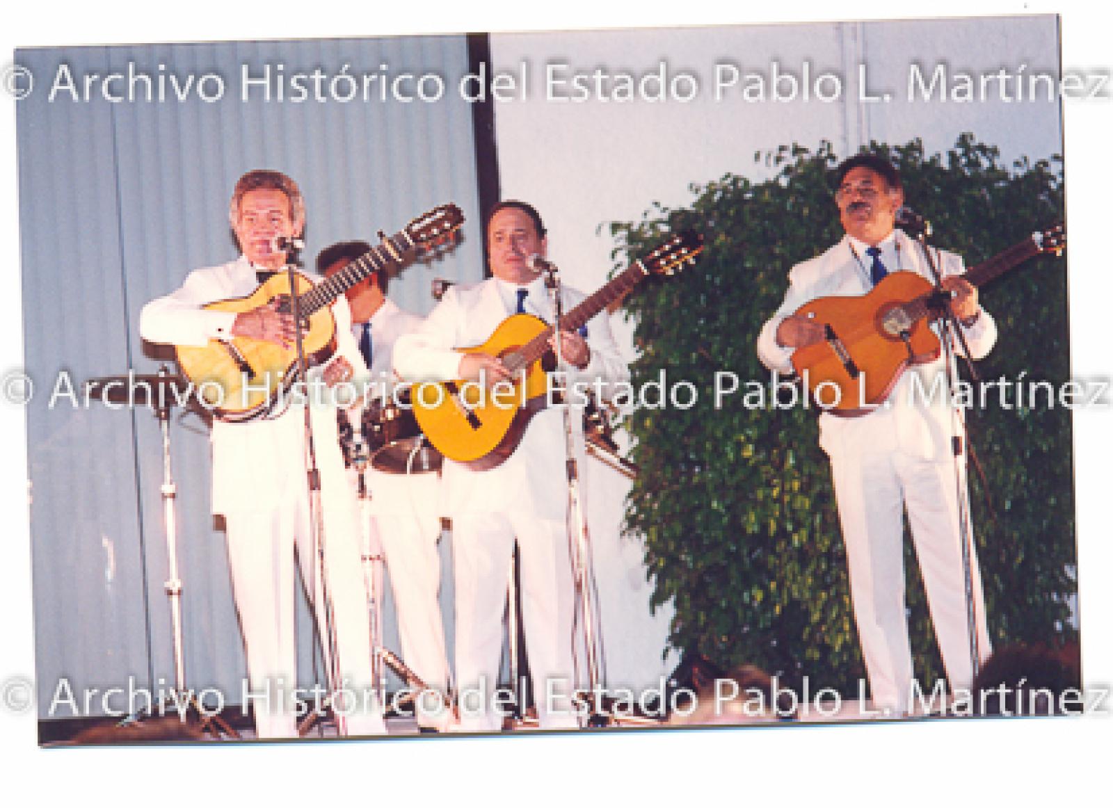 Músicos tocan sobre escenario.
