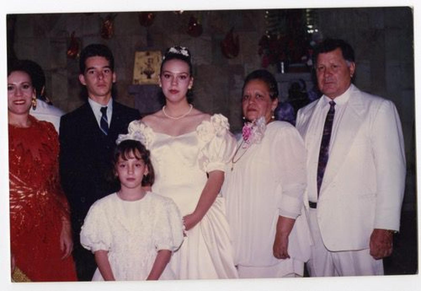 Niña, mujeres y hombre que visten elegante en iglesia.