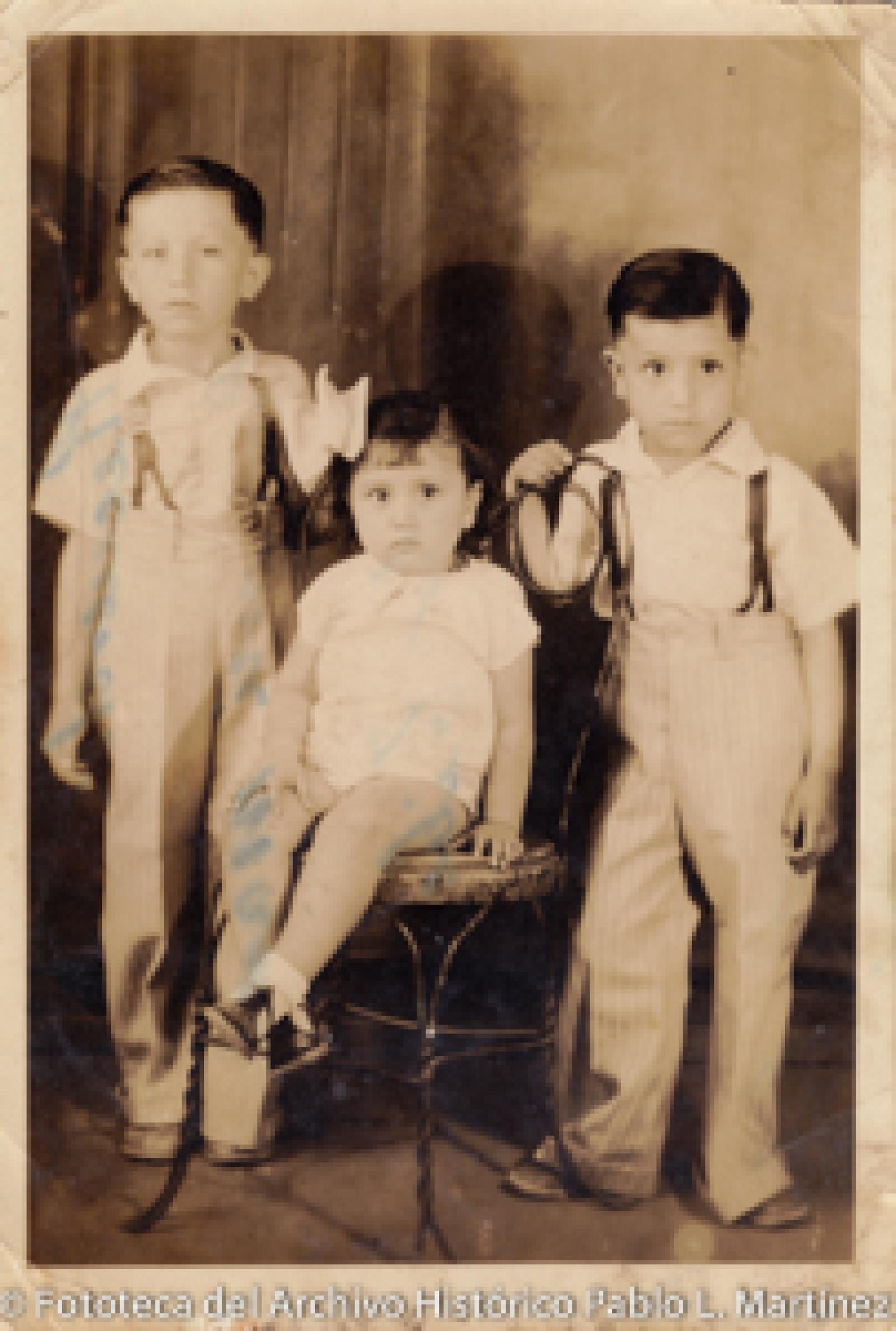 Niña sentada en medio de dos niños.