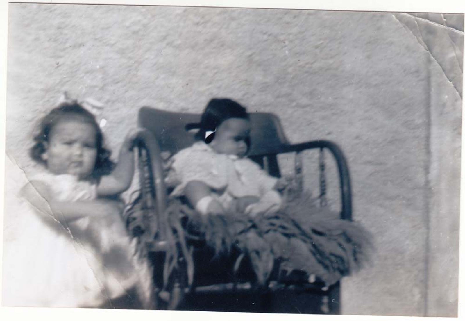 Niña y bebé en mecedora.
