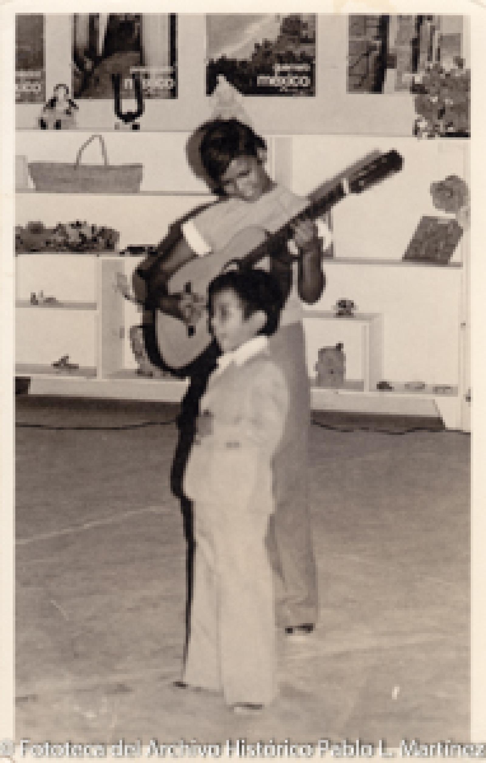 Niño al lado de mujer con guitarra