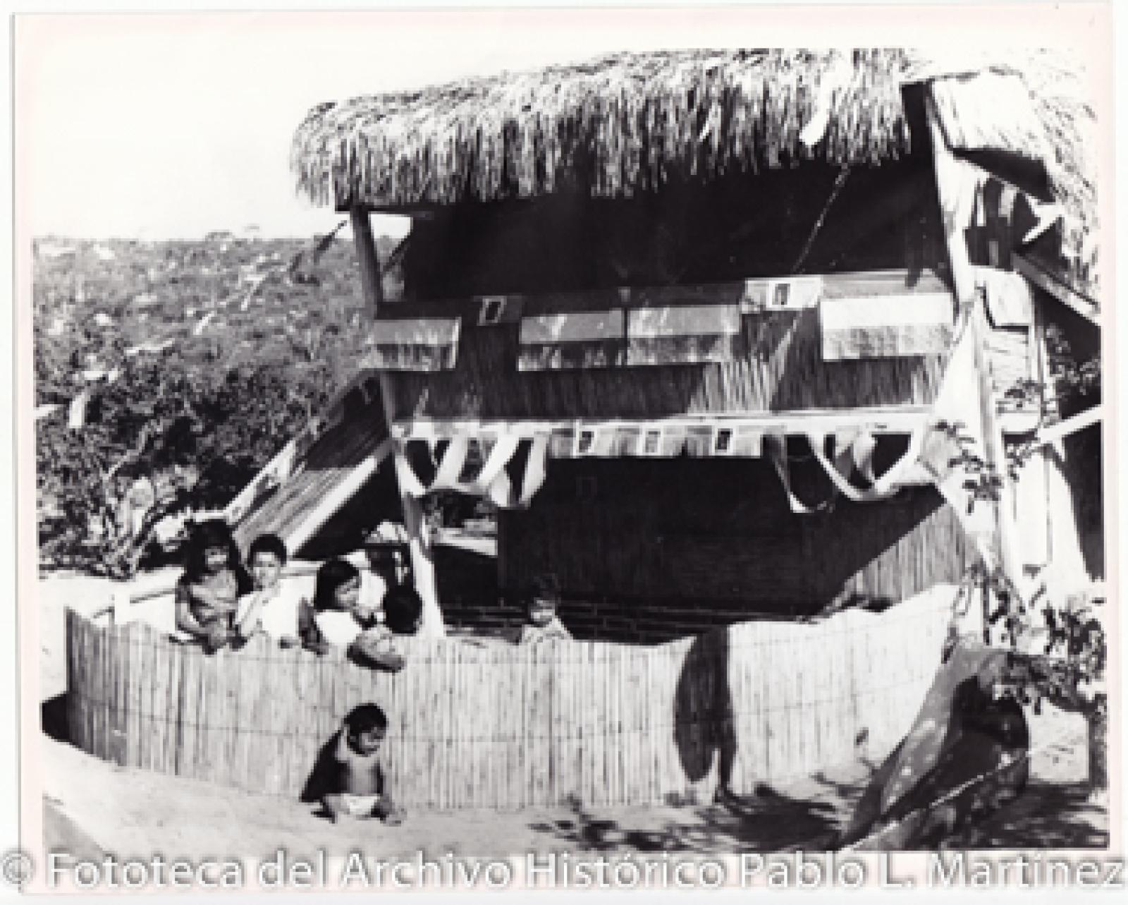 Niños frente a cabaña.