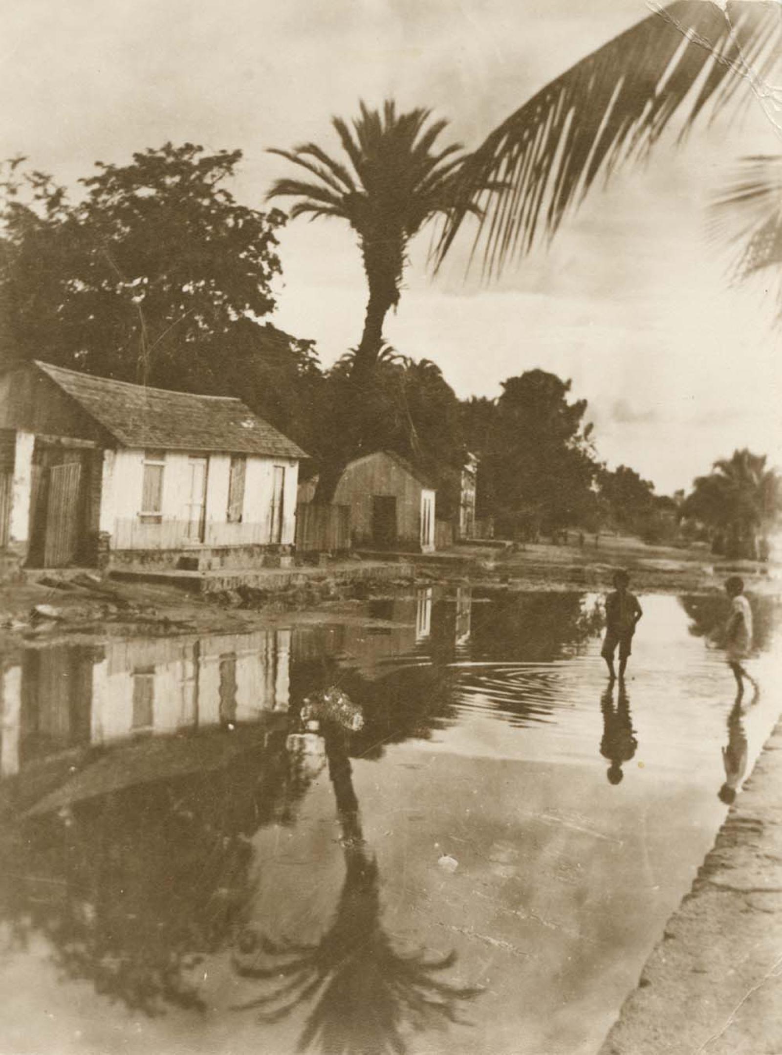 Niños que caminan en calle inundada.