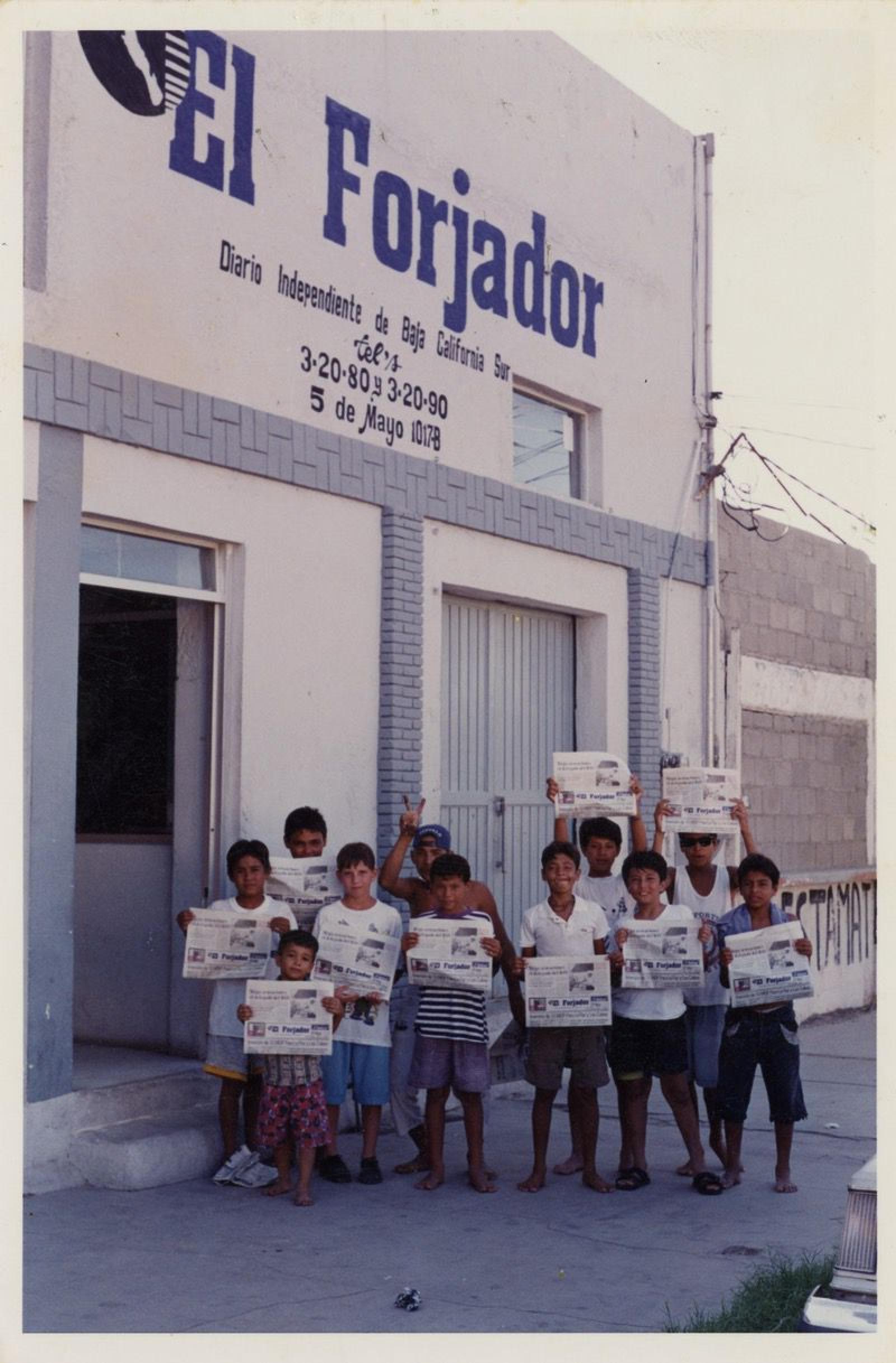 Niños sostienen periódicos de “El Forjador”, sobre la calle 5 de Mayo.