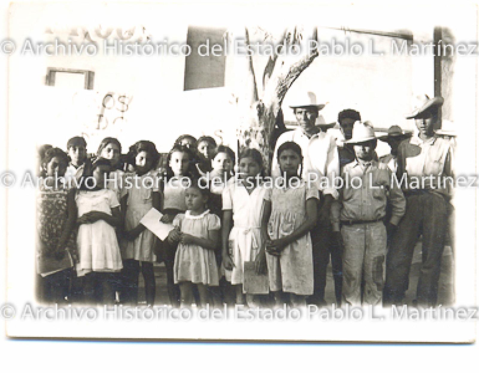 Niños y hombres frente a escuela “Andres Quintana Roo”.
