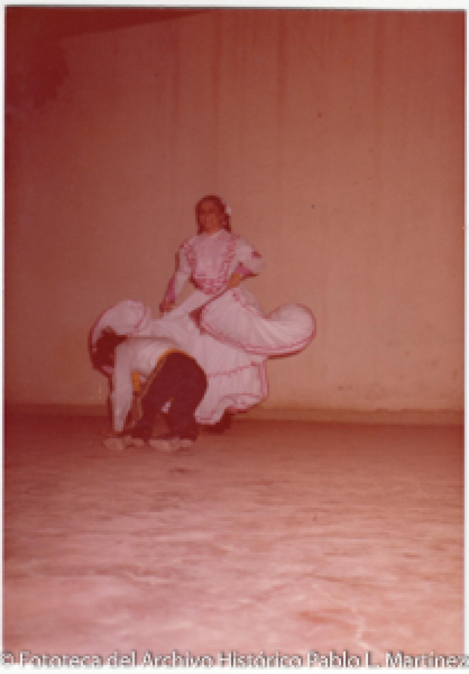 Pareja de bailarines que visten trajes folklóricos mexicanos.