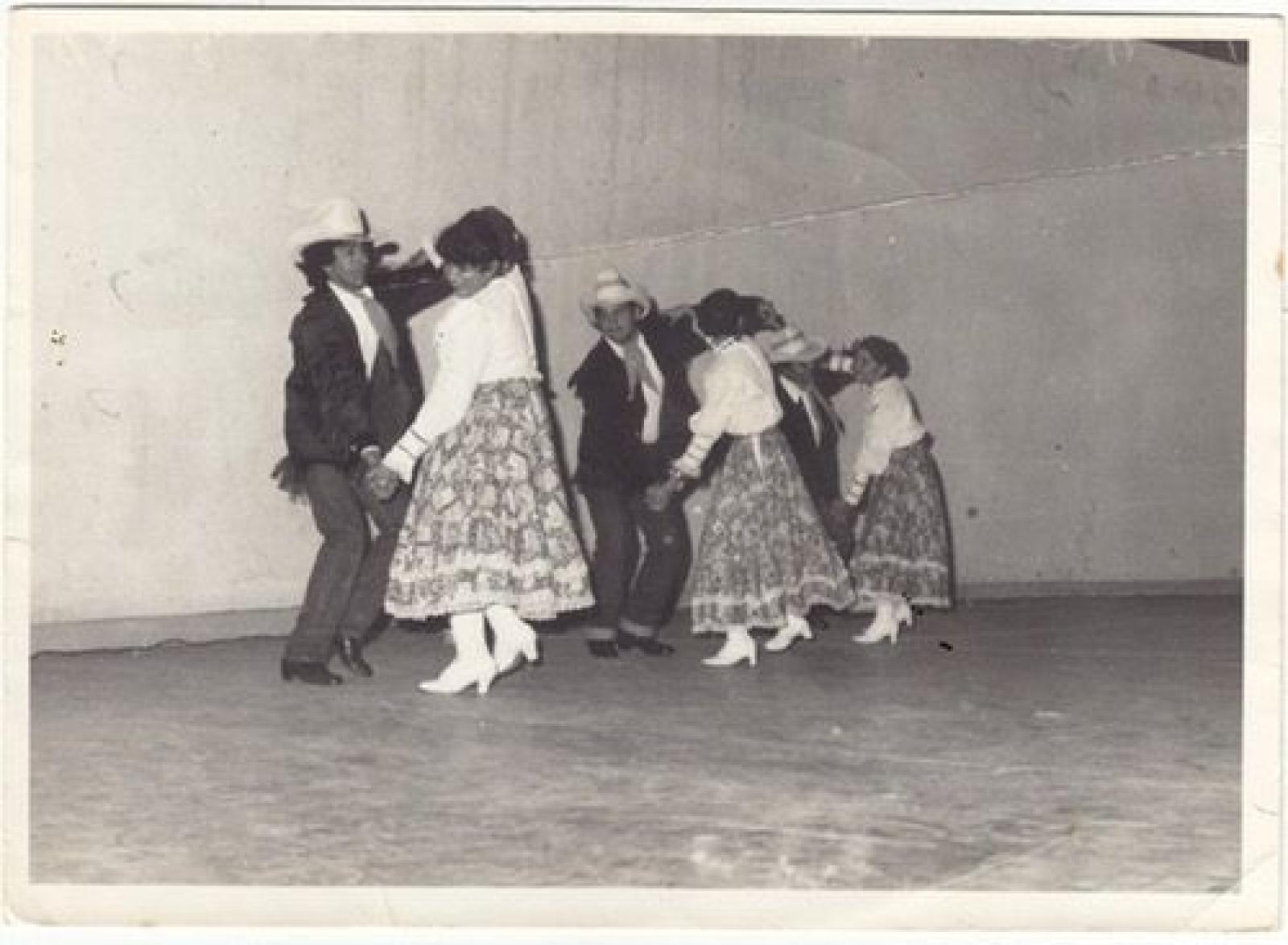 Parejas que bailan y visten traje folklórico del norte de México.