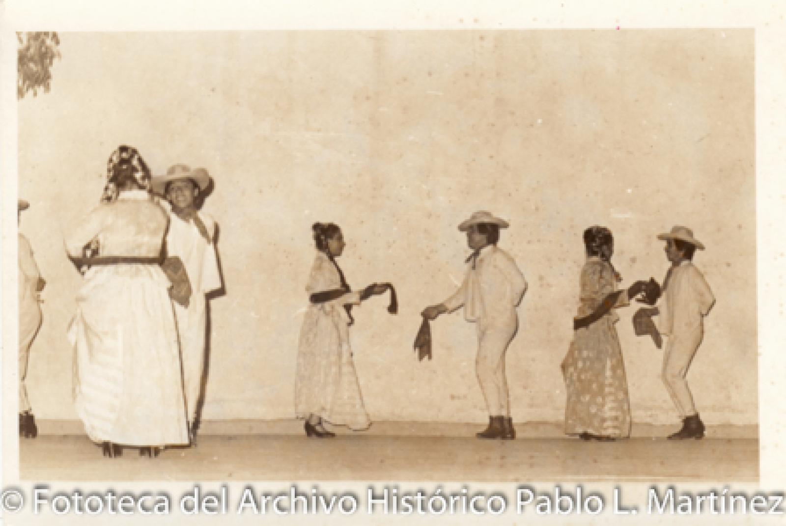 Parejas que visten con trajes típicos mexicanos.
