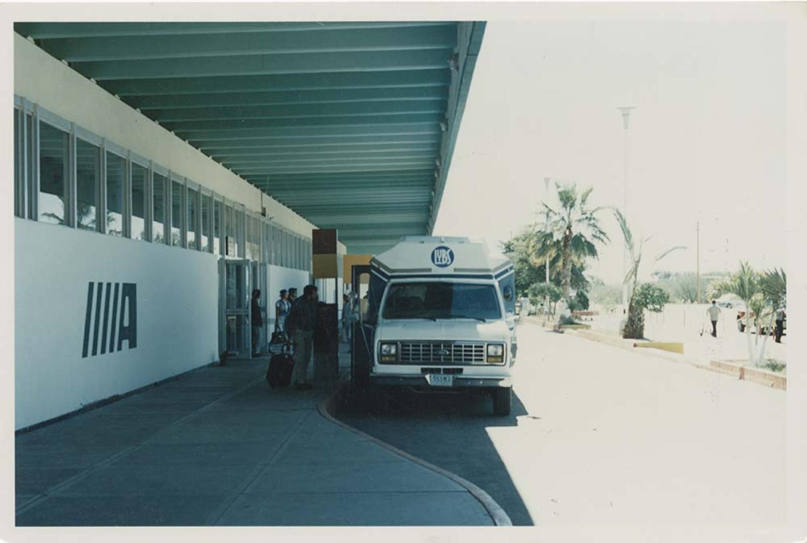 Pasajeros, en exterior de aeropuerto.