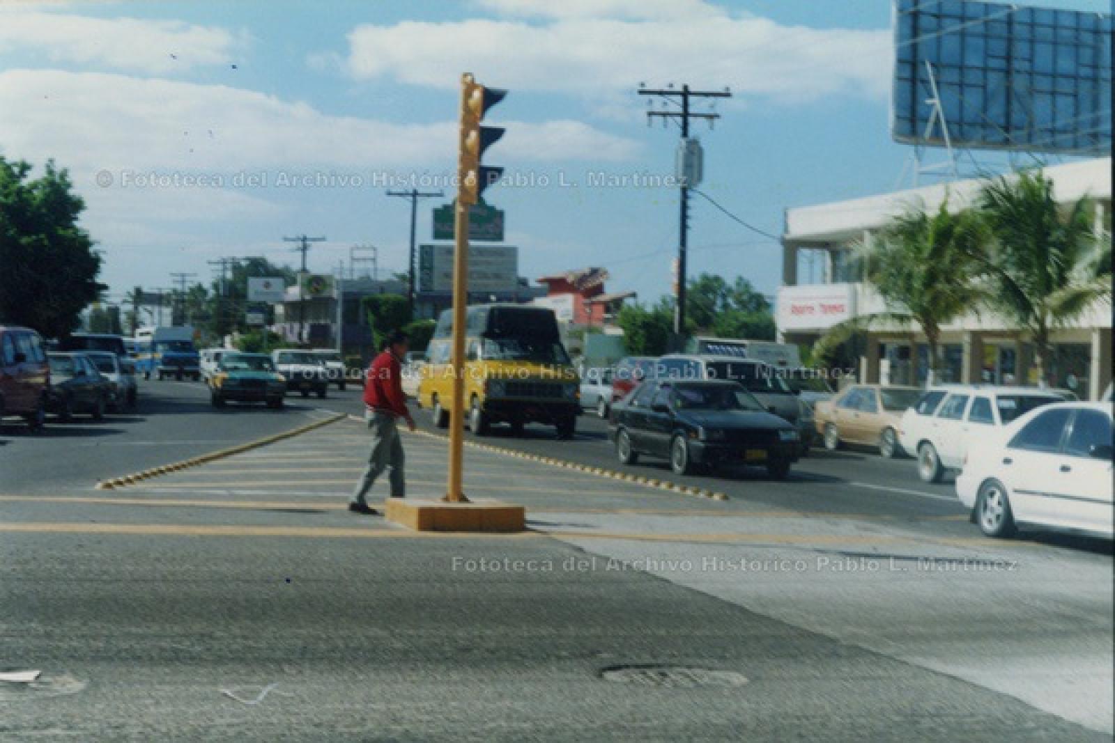 Peatón espera turno para cruzar calle transitada.