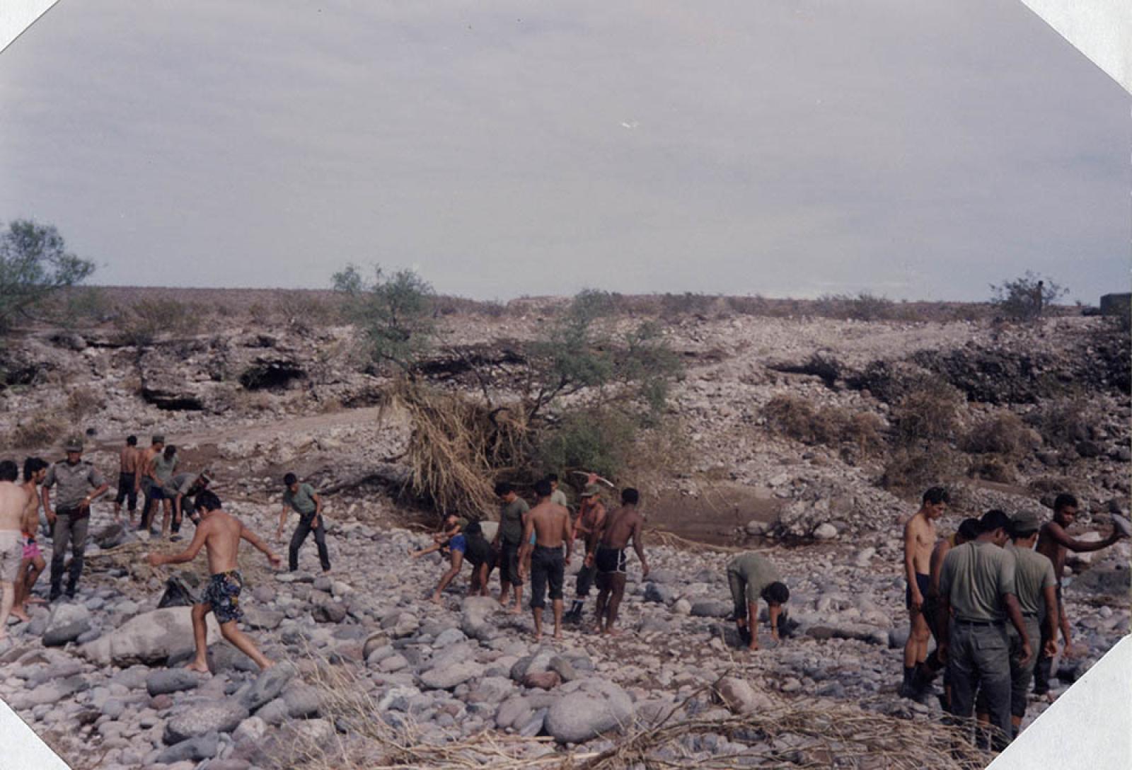 Personal militar y población civil limpiando desastre en zonas devastadas por el paso del huracán Lester.