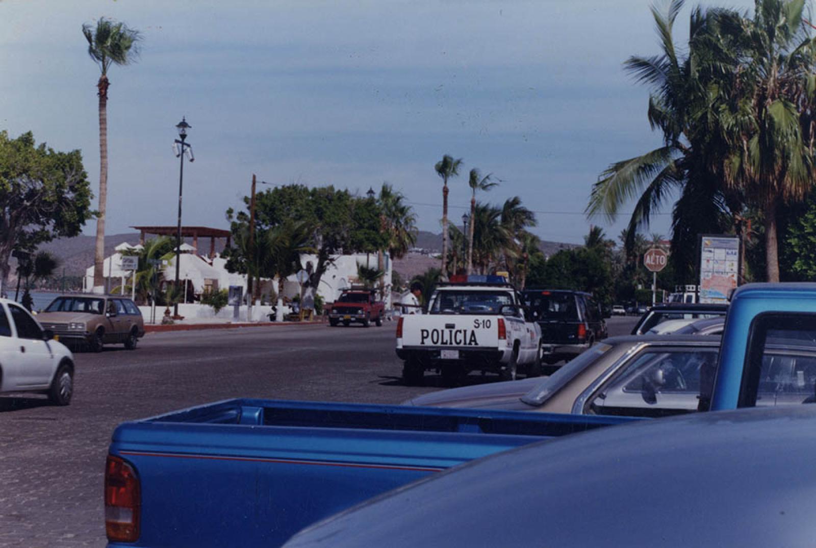 Policía de tránsito inspeccionando revista a automovilistas, malecón de La Paz.