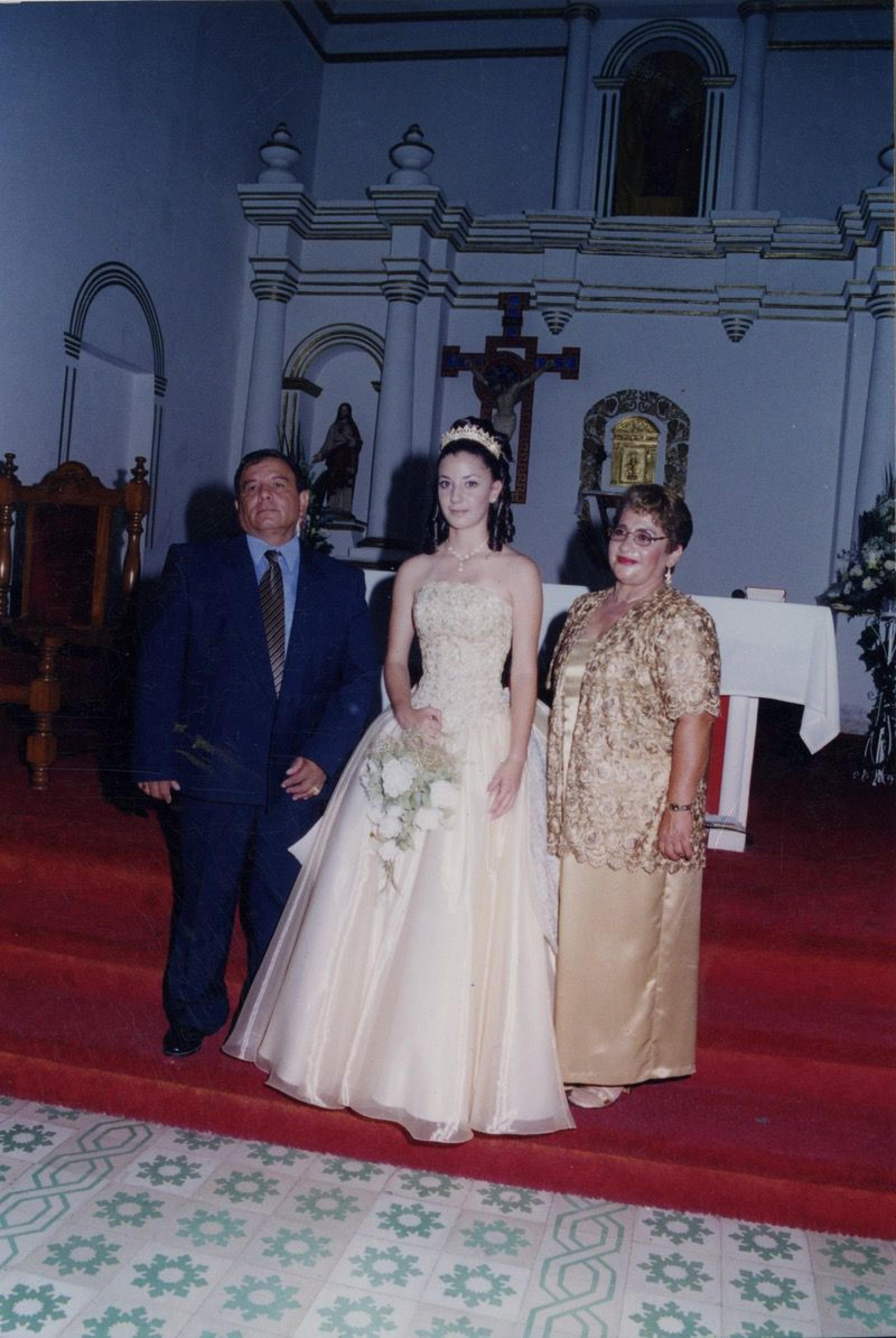 “Quinceañera acompañada por sus padrinos”.