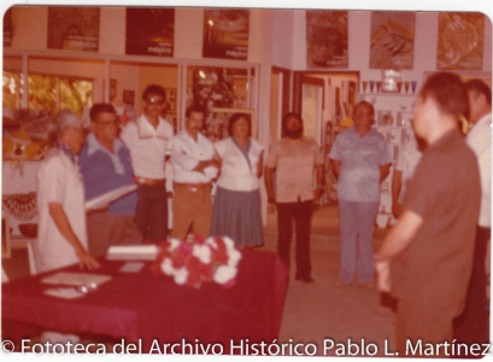 Retrato de grupo frente a mesa en museo regional de artesanías
