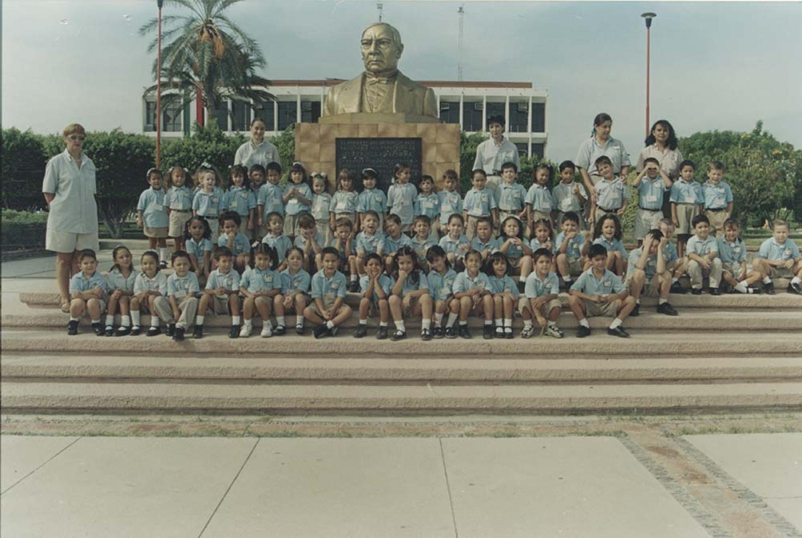 Retrato de grupo, frente al busto de Benito Juárez.