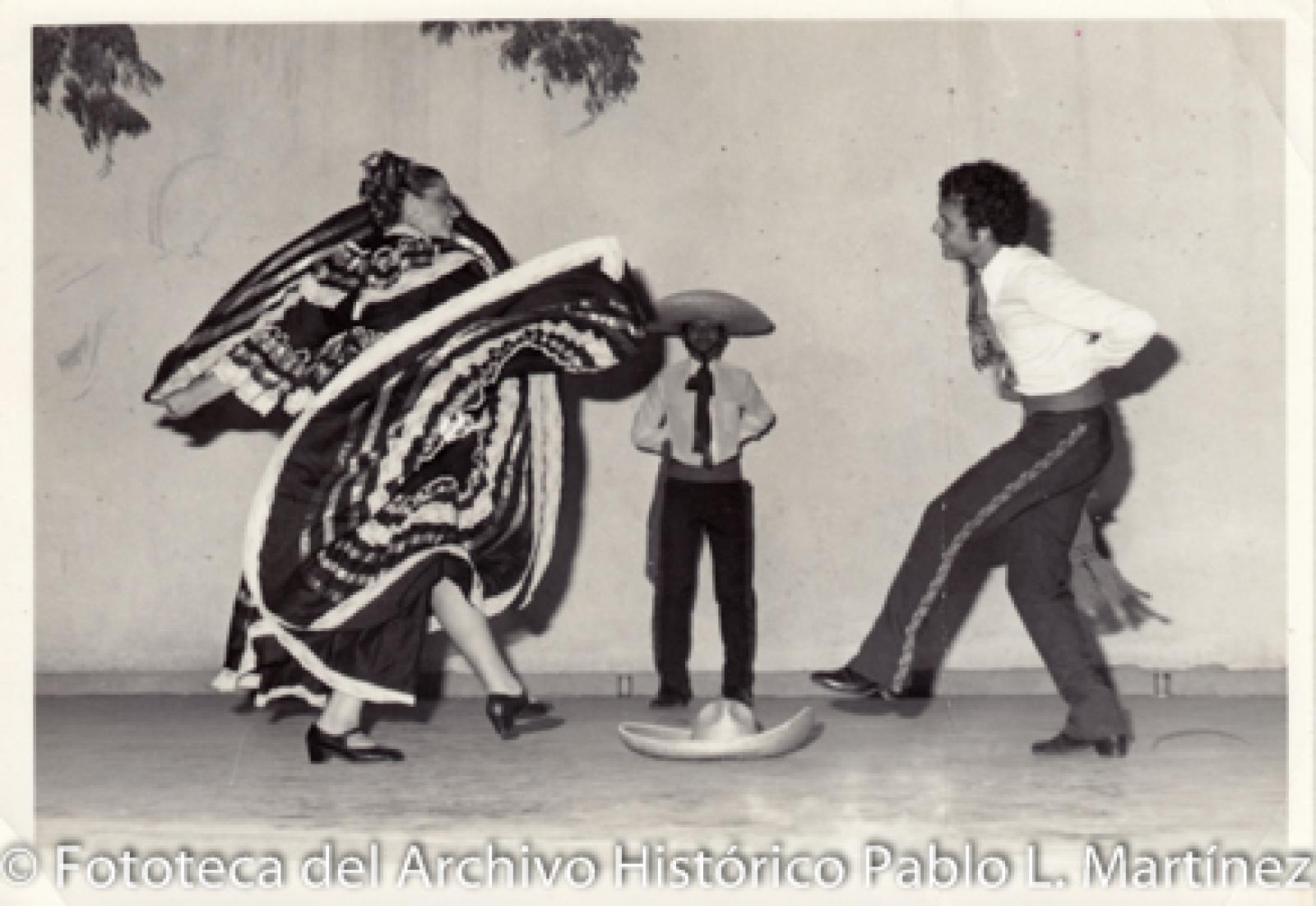 Retrato de grupo que  baila alrededor de sombrero.