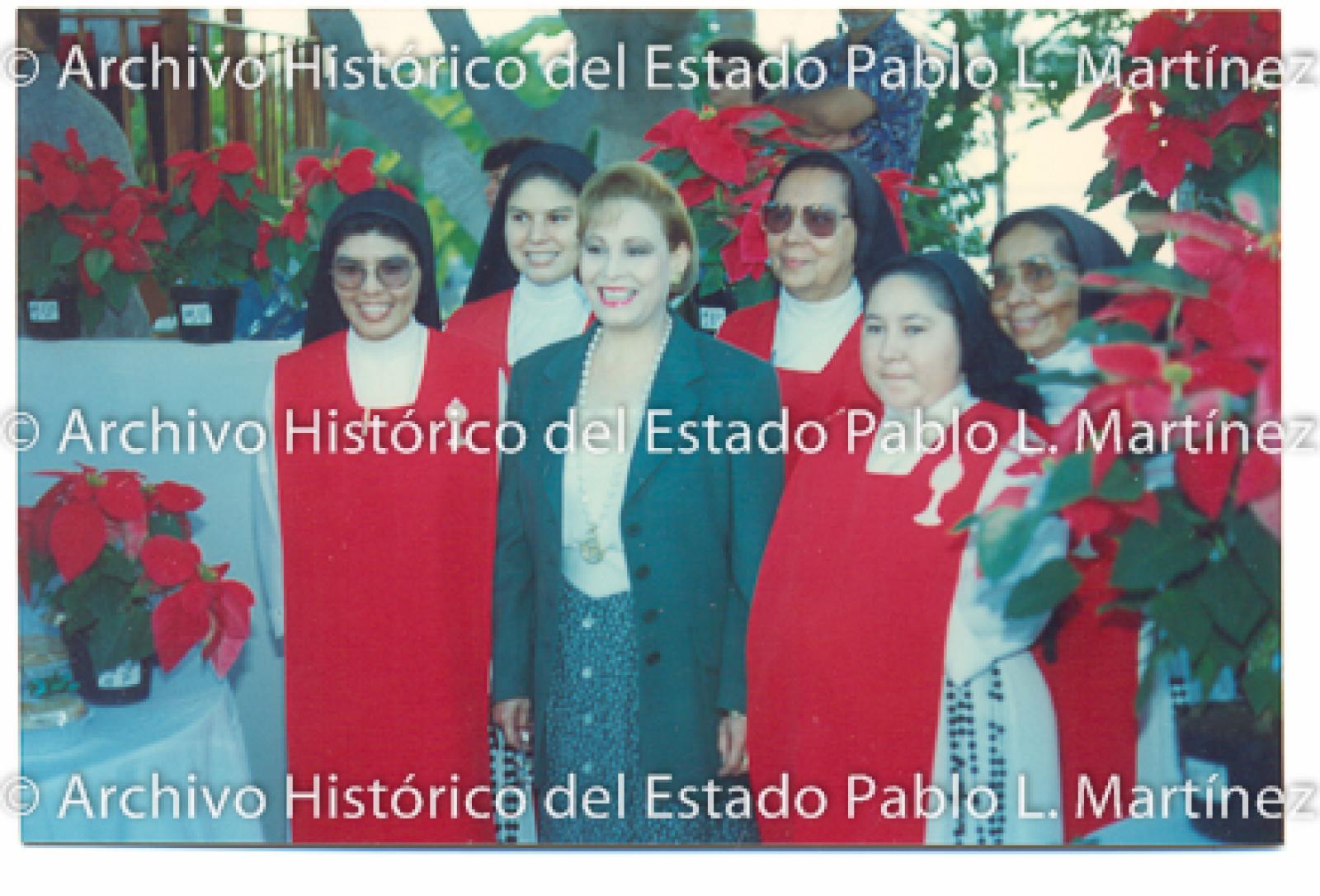 Retrato de mujer con monjas a su lado.