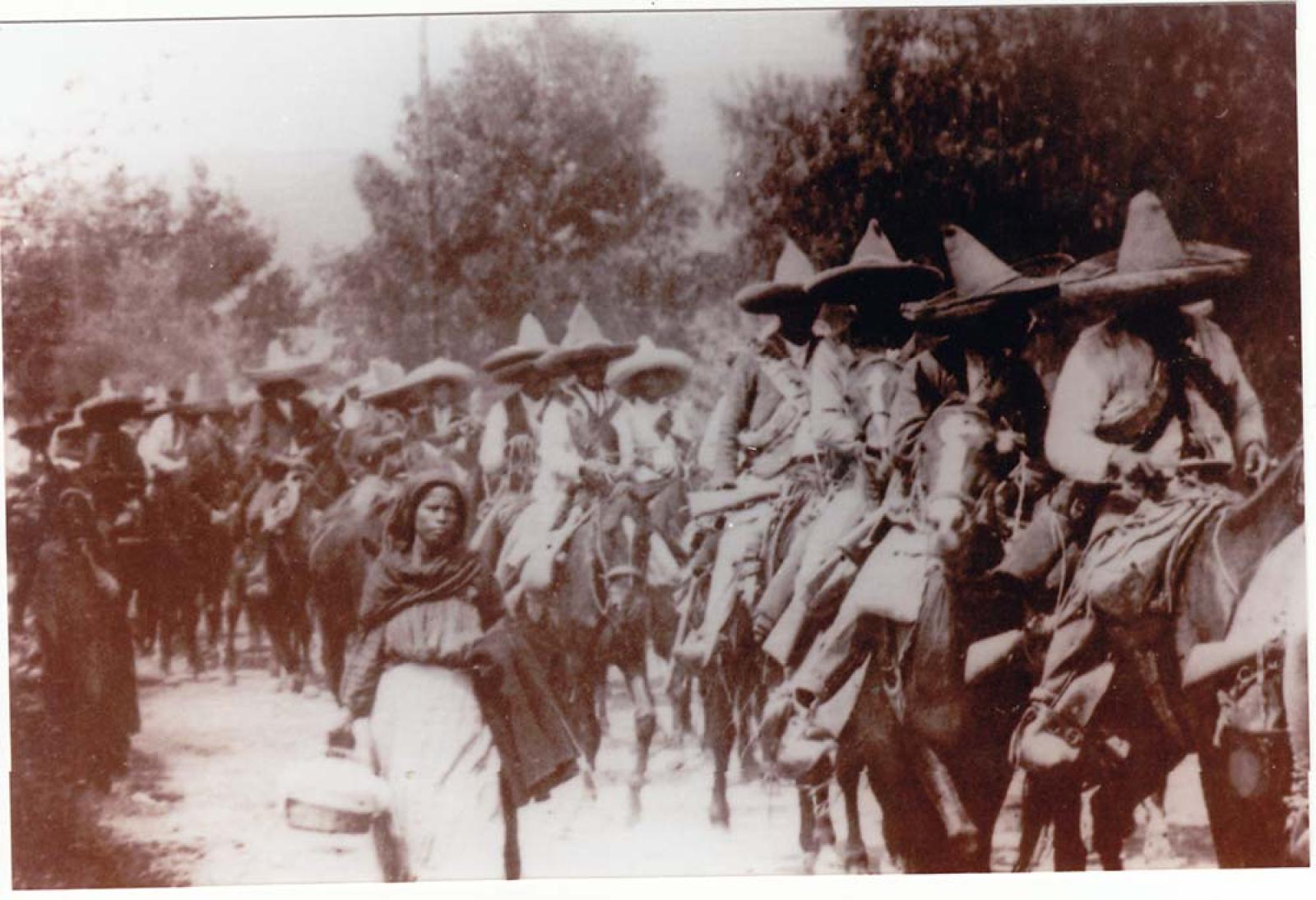 Revolucionarios a caballo y soldaderas.
