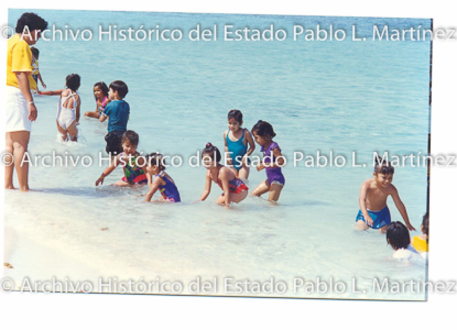 Señora con niños en la playa.