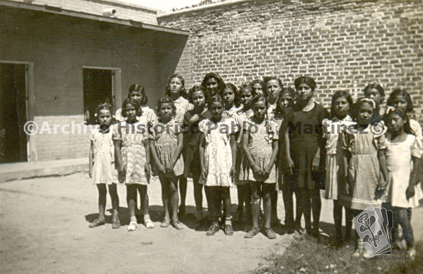 Servicio escolar en el dispensario. Grupo de niñas posan para fotografía.
