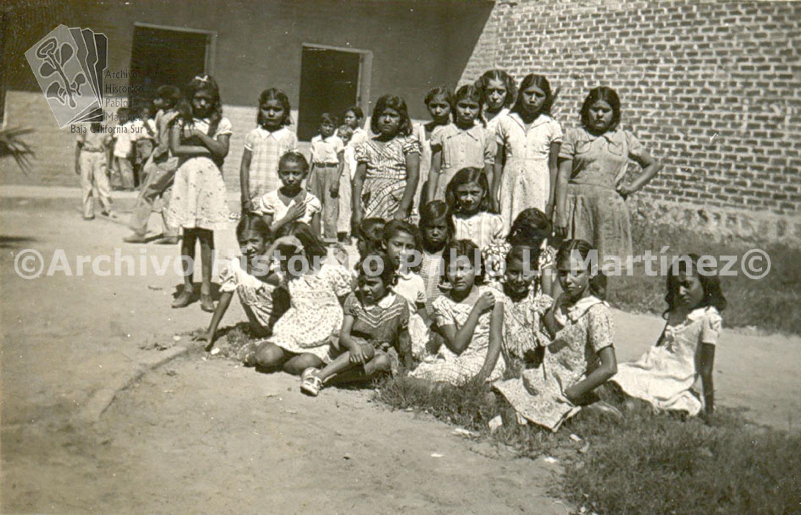 Servicio escolar en el dispensario. Niñas posan para fotografía de grupo.