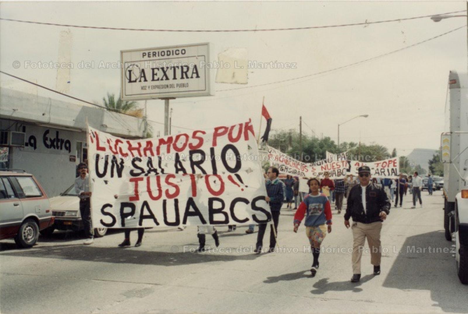 Sindicato del Personal Académico de la UABCS (SPAUABCS) en marcha con banderas rojinegras.