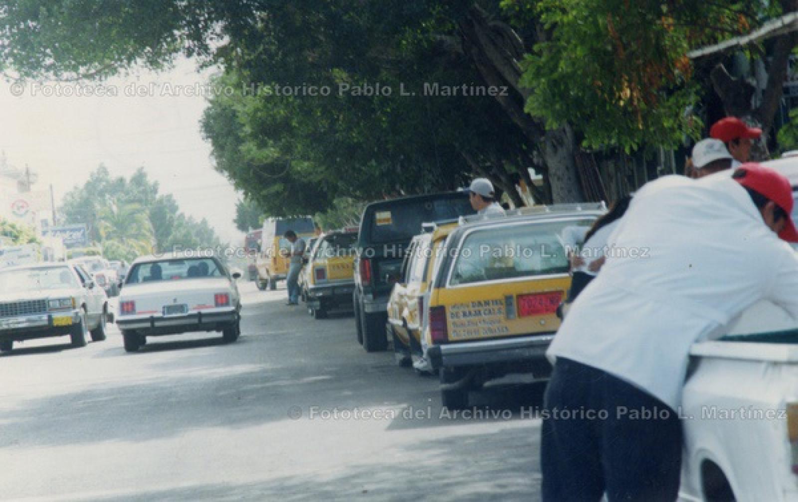 Tránsito vehicular y taxis estacionados.