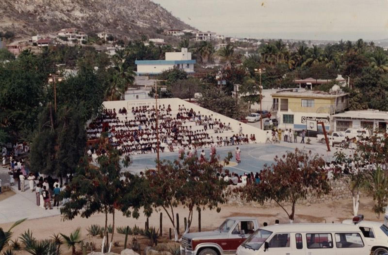 Vista panorámica de baile folklórico ejecutado en cancha de básquetbol.