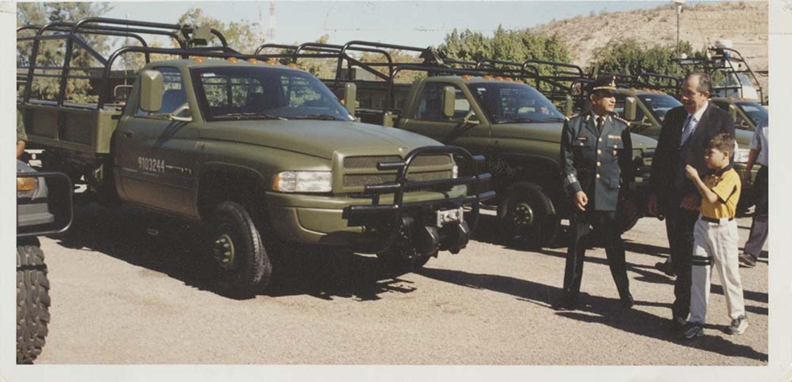Wilson y acompañantes, frente a camionetas del ejército.